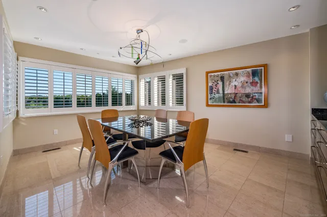 a view of a dining room with furniture large windows and wooden floor
