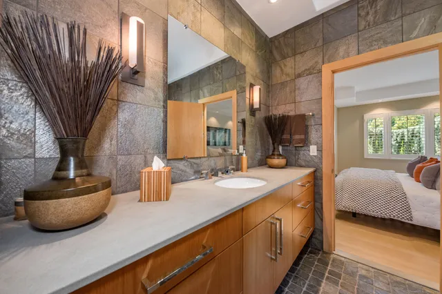 a bathroom with a double vanity sink a mirror and bathtub