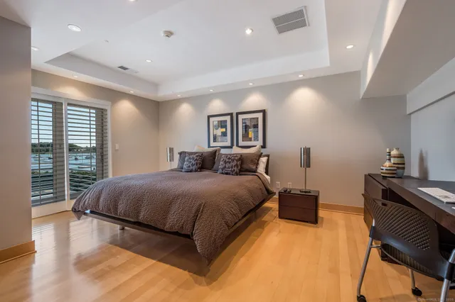 a spacious bedroom with a bed and wooden floor