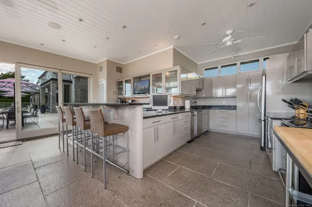 a kitchen with kitchen island a counter top space a sink stainless steel appliances and cabinets