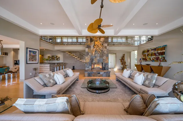 a living room with furniture a chandelier and a large window