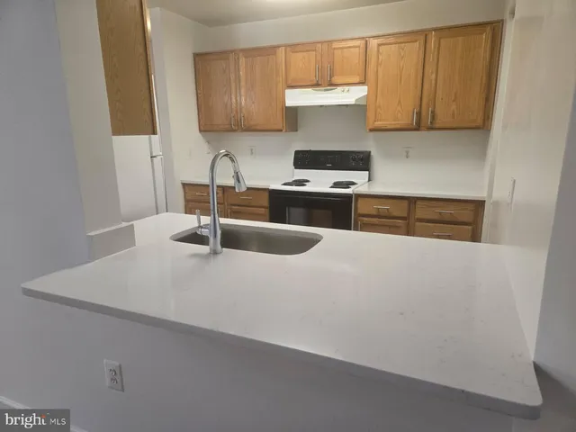 a kitchen with a sink a stove and cabinets