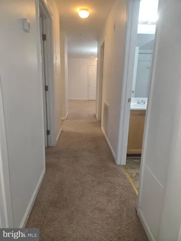 a view of a hallway with closet and wooden floor