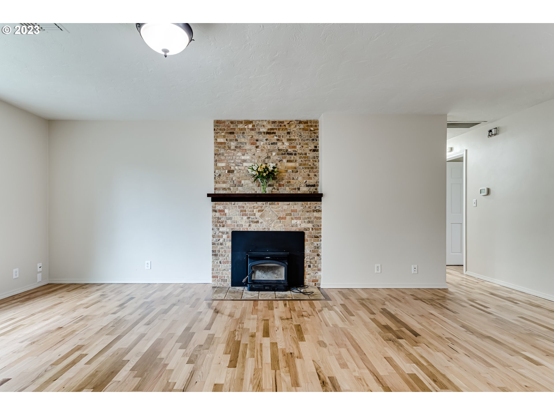 833 Elm Drive Eugene, OR 97404 - Photo 3 of 20 a view of an empty room with wooden floor and a fireplace