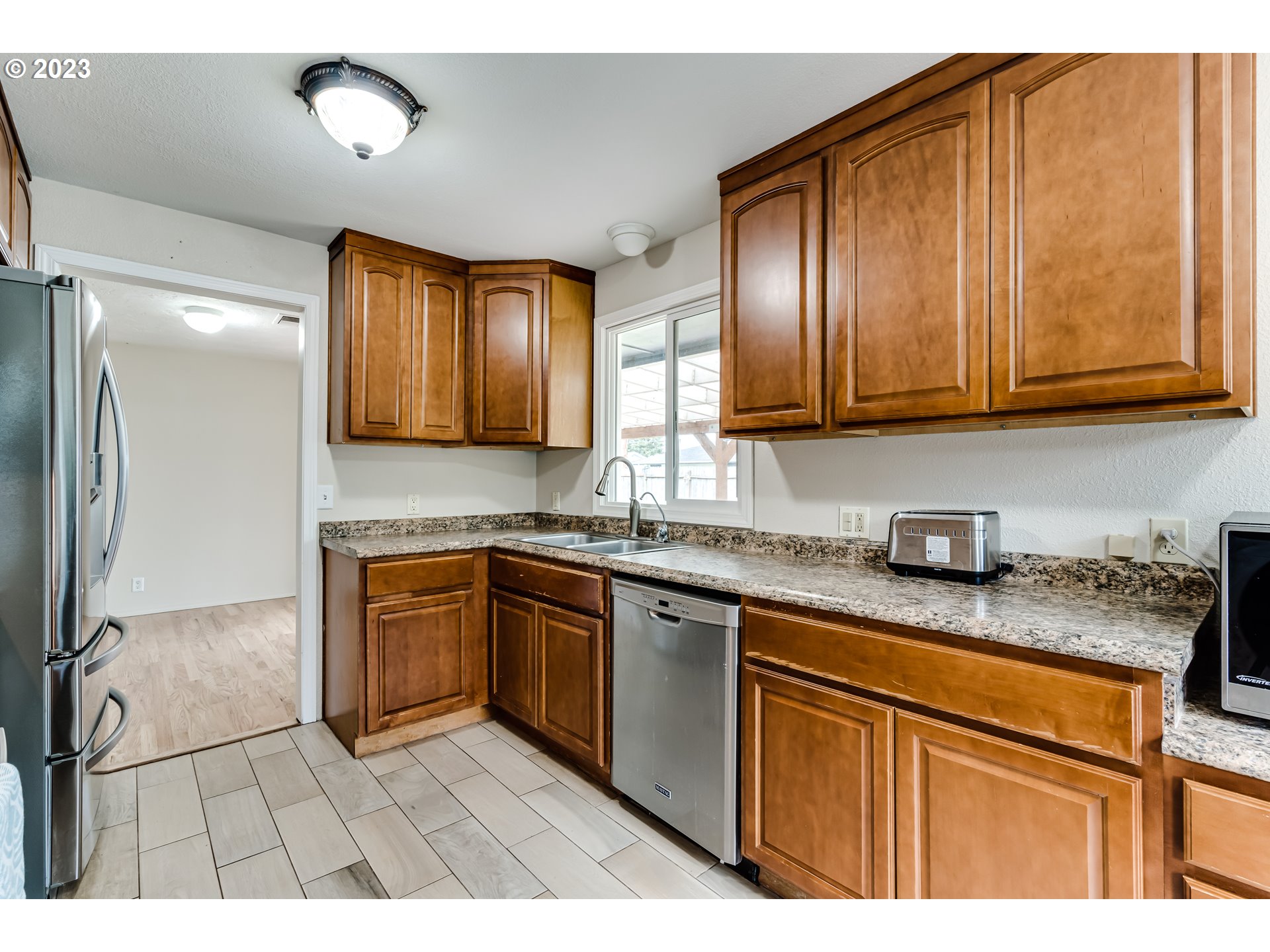 833 Elm Drive Eugene, OR 97404 - Photo 6 of 20 a kitchen with stainless steel appliances granite countertop wooden cabinets a sink and dishwasher