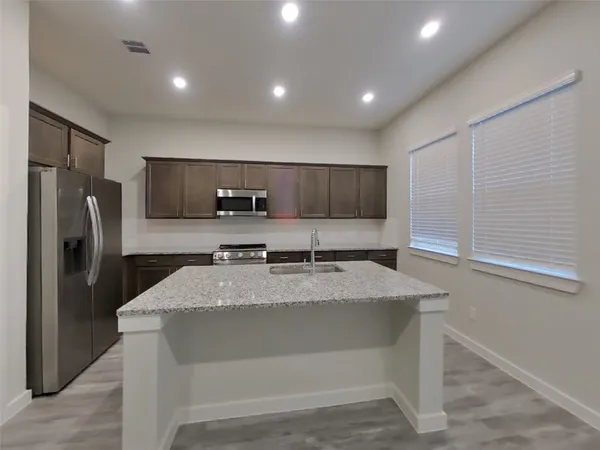 a large kitchen with kitchen island a sink stainless steel appliances and cabinets