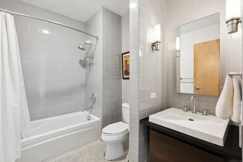 a bathroom with a sink toilet vanity and shower