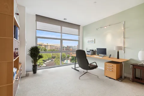 a view of a workspace with furniture and a window