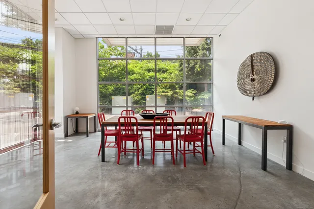 a dining room with furniture and a large window