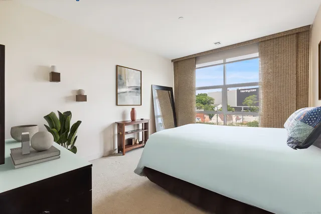 a bedroom with a large bed and a potted plant