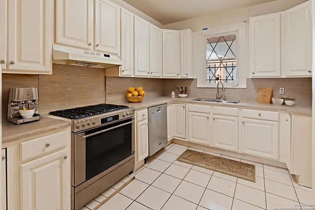 a kitchen with cabinets appliances and a window