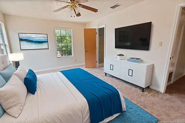 a bedroom with a bed and a flat tv screen on dresser