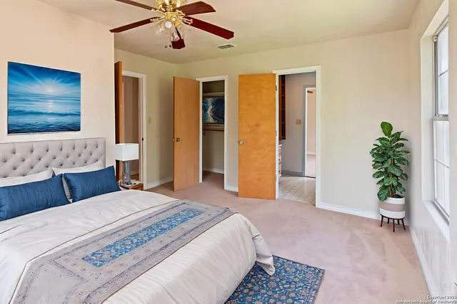 a spacious bedroom with a bed and a potted plant