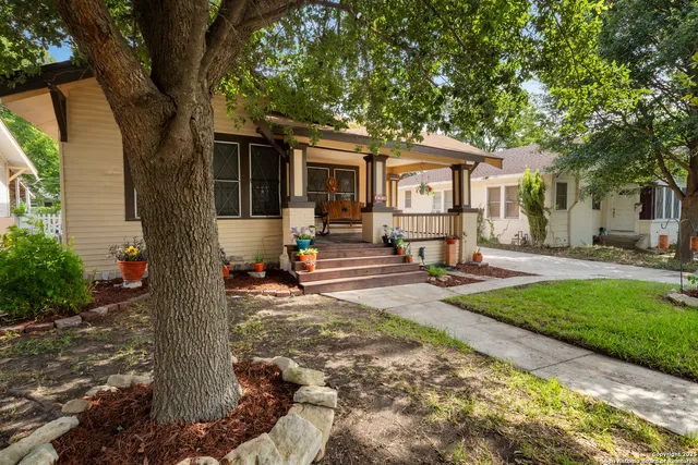 a view of a house with backyard and a tree