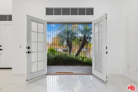 a view of a dining room with furniture a kitchen and chandelier