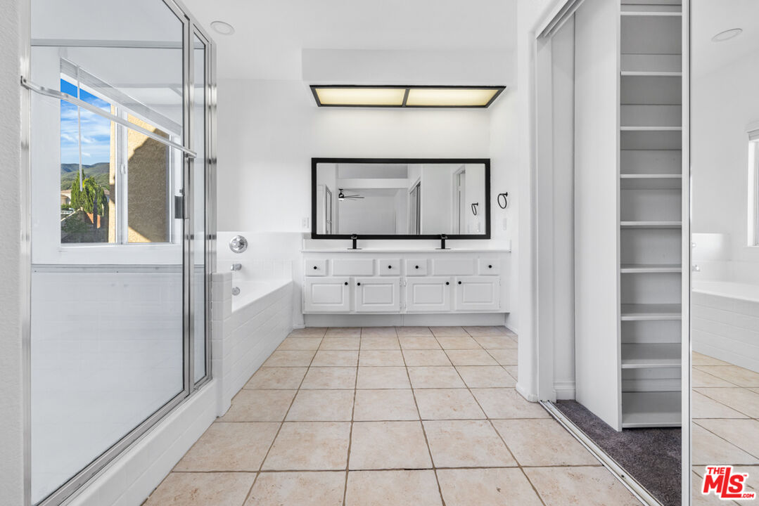 6758 Ridgeline Avenue San Bernardino, CA 92407 - Photo 25 of 67 a bathroom with a sink a mirror and a shower
