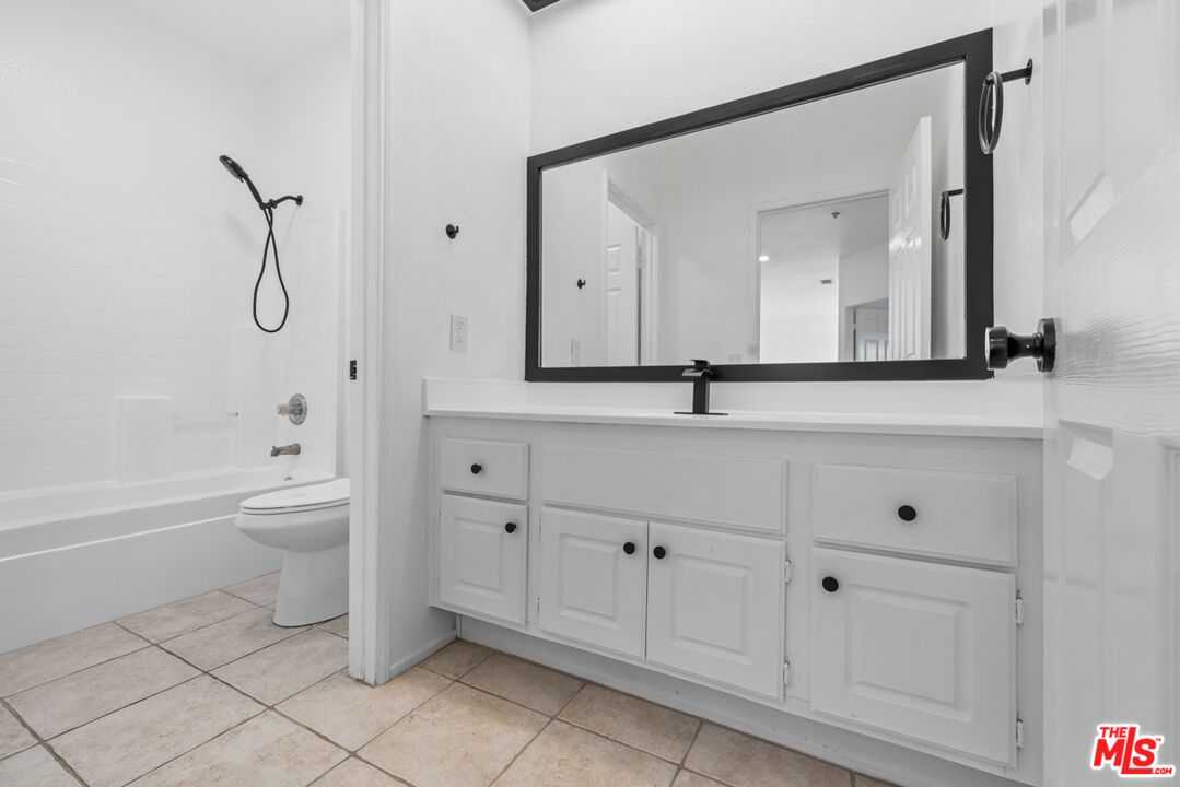 6758 Ridgeline Avenue San Bernardino, CA 92407 - Photo 35 of 67 a bathroom with a toilet a sink a mirror and a bathtub