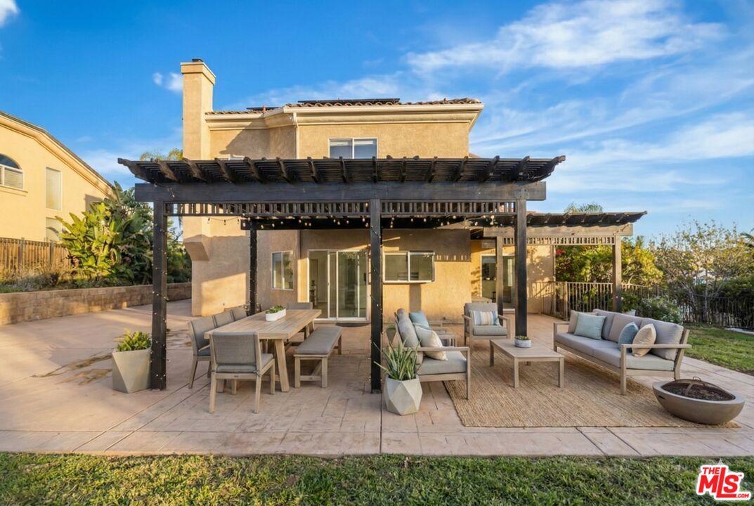 6758 Ridgeline Avenue San Bernardino, CA 92407 - Photo 47 of 67 a view of a patio with table and chairs potted plants with wooden fence