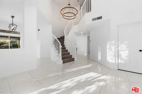 a living room with furniture a potted plant and a large window