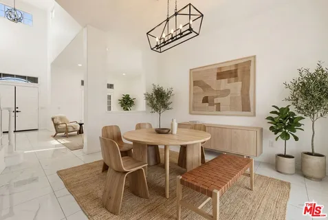 a living room with furniture potted plant and a large window