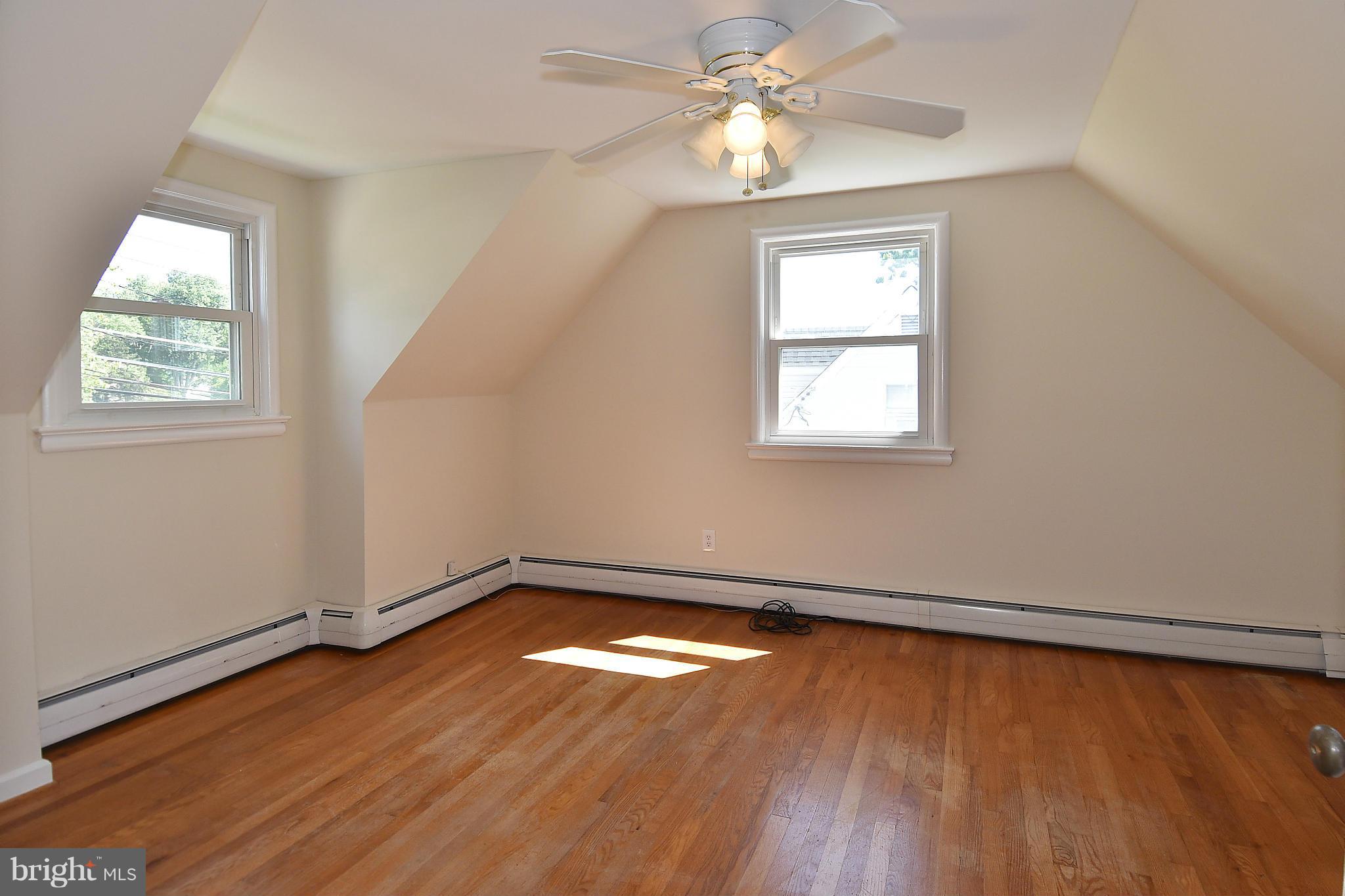 3206 Weller Road Silver Spring, MD 20906 - Photo 23 of 30 an empty room with wooden floor chandelier fan and windows