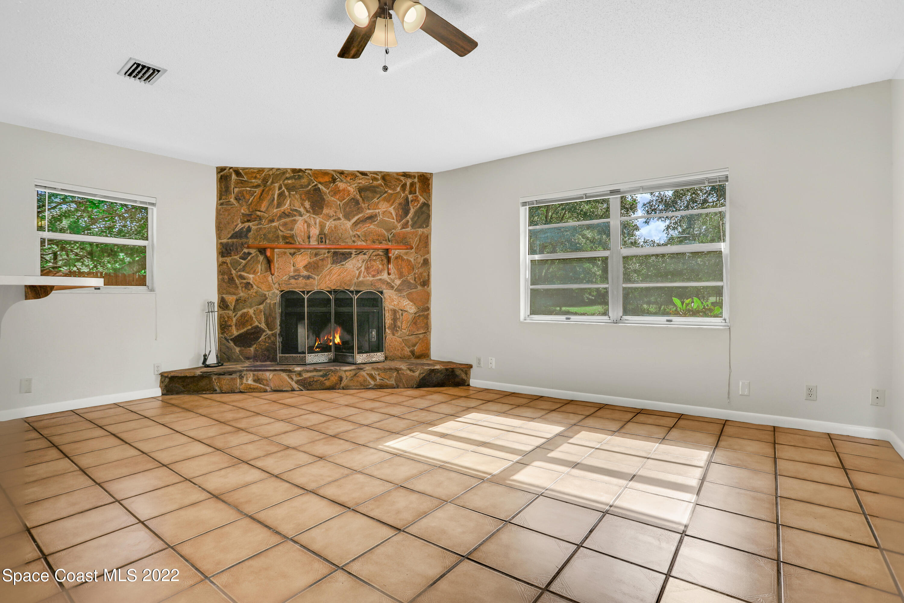 4124 April Lane Mims, FL 32754 - Photo 18 of 44 a view of an empty room with window a fireplace and chandelier fan