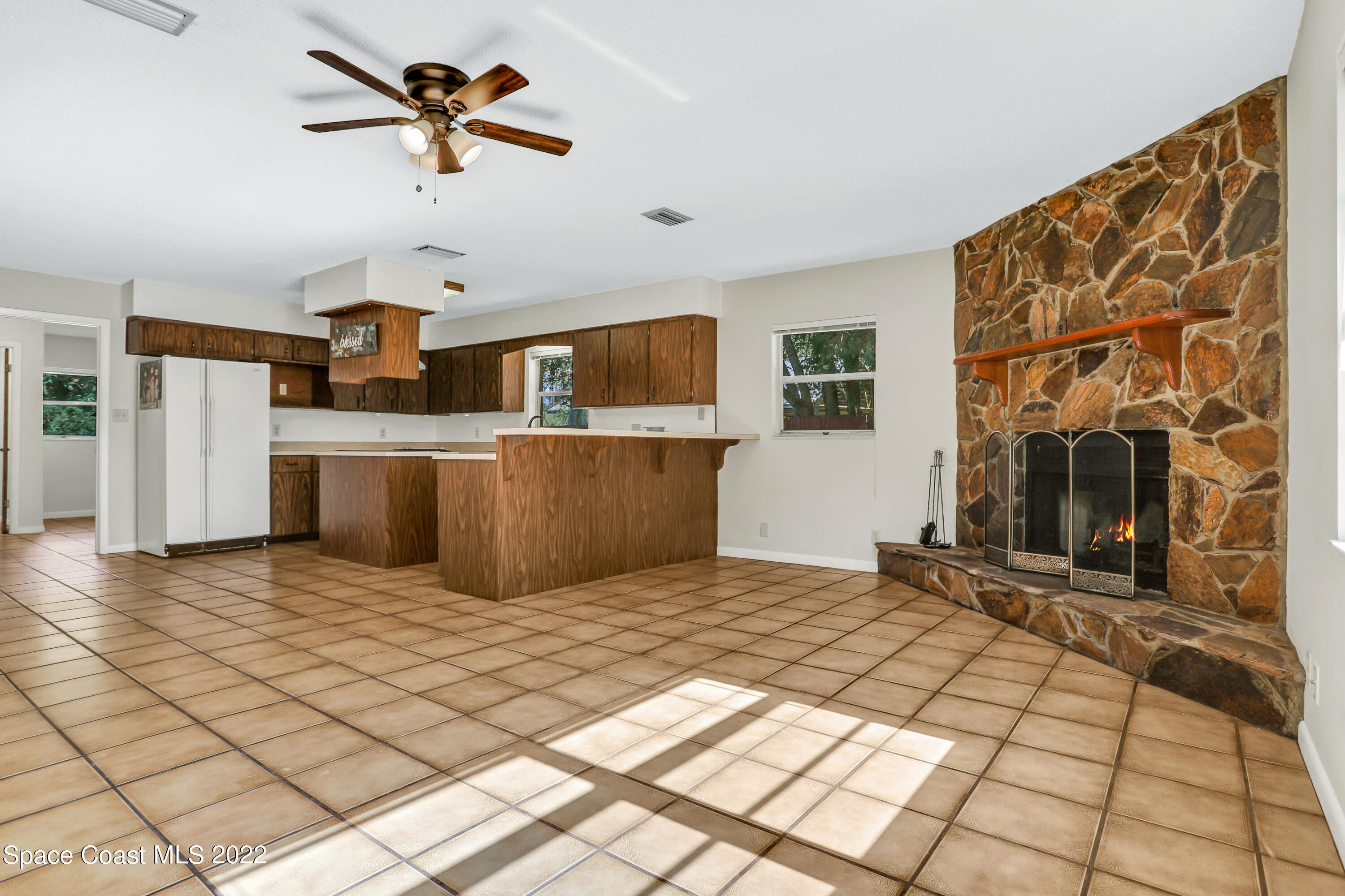 4124 April Lane Mims, FL 32754 - Photo 19 of 44 a living room with stainless steel appliances furniture a fireplace and a flat screen tv