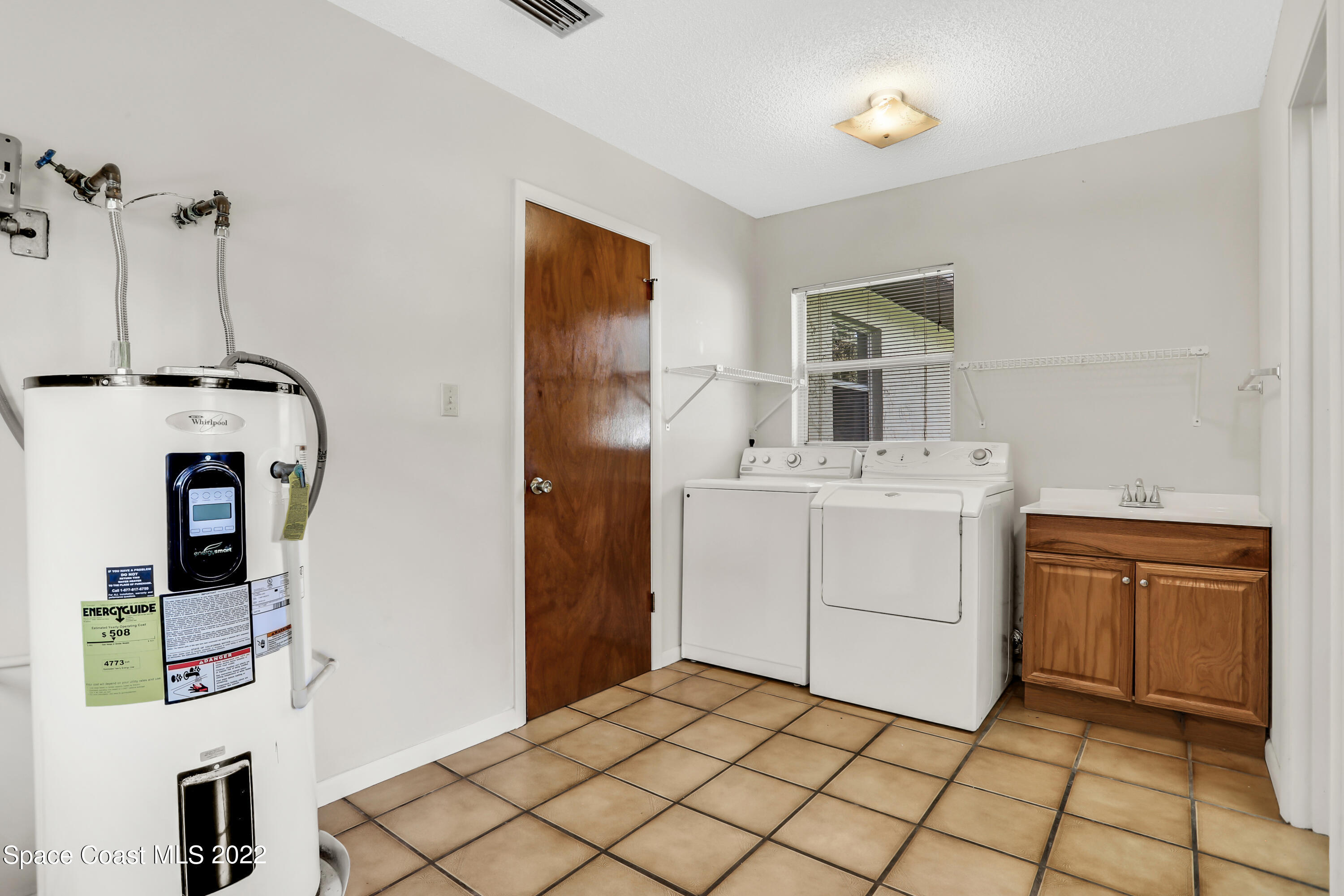 4124 April Lane Mims, FL 32754 - Photo 31 of 44 a utility room with cabinets washer and dryer