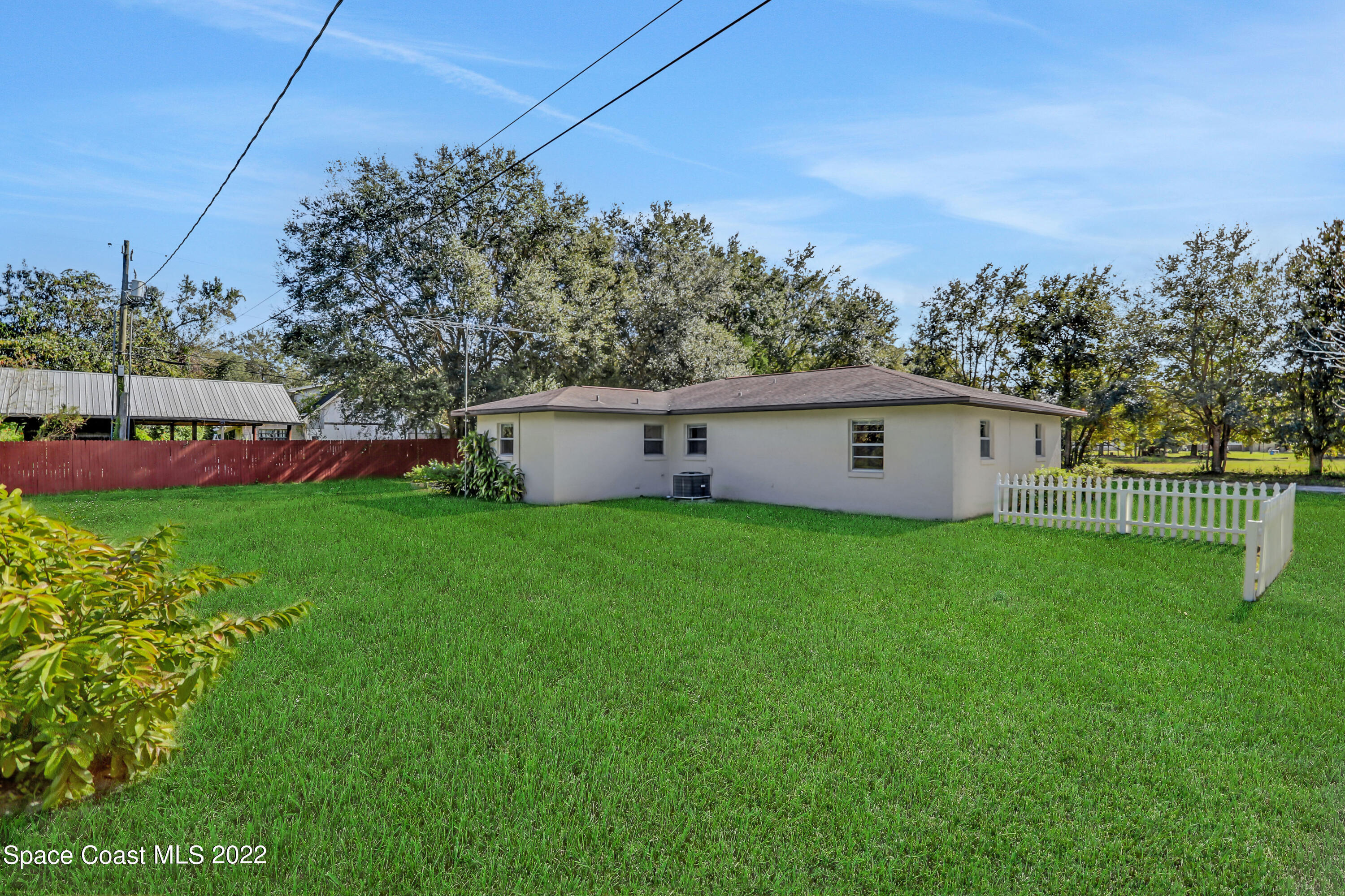 4124 April Lane Mims, FL 32754 - Photo 6 of 44 a view of a white house in front of a big yard with large trees