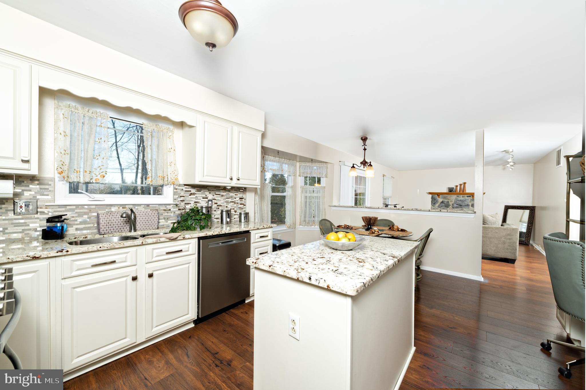72 Rosalind Circle Sicklerville, NJ 08081 - Photo 8 of 47 a open kitchen with granite countertop a sink dishwasher stove and white cabinets with wooden floor