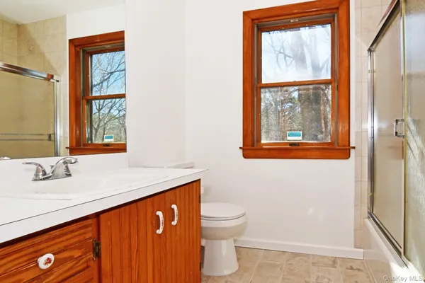 a bathroom with a sink a toilet and a window