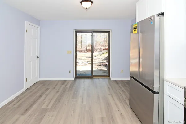 an empty room with wooden floor closet and windows
