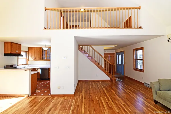 a view of a livingroom with wooden floor and staircase