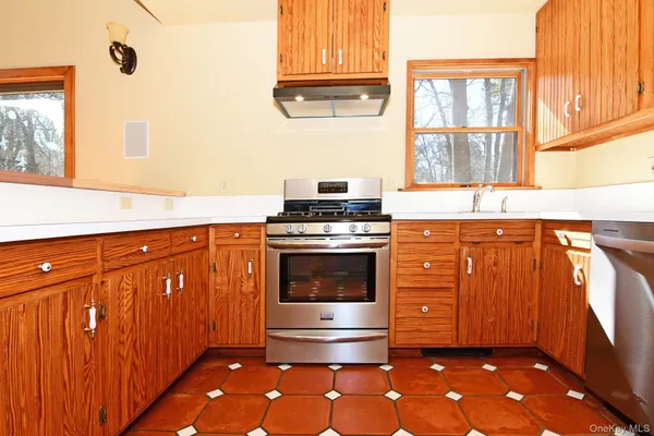 a kitchen with granite countertop a stove a sink and a window