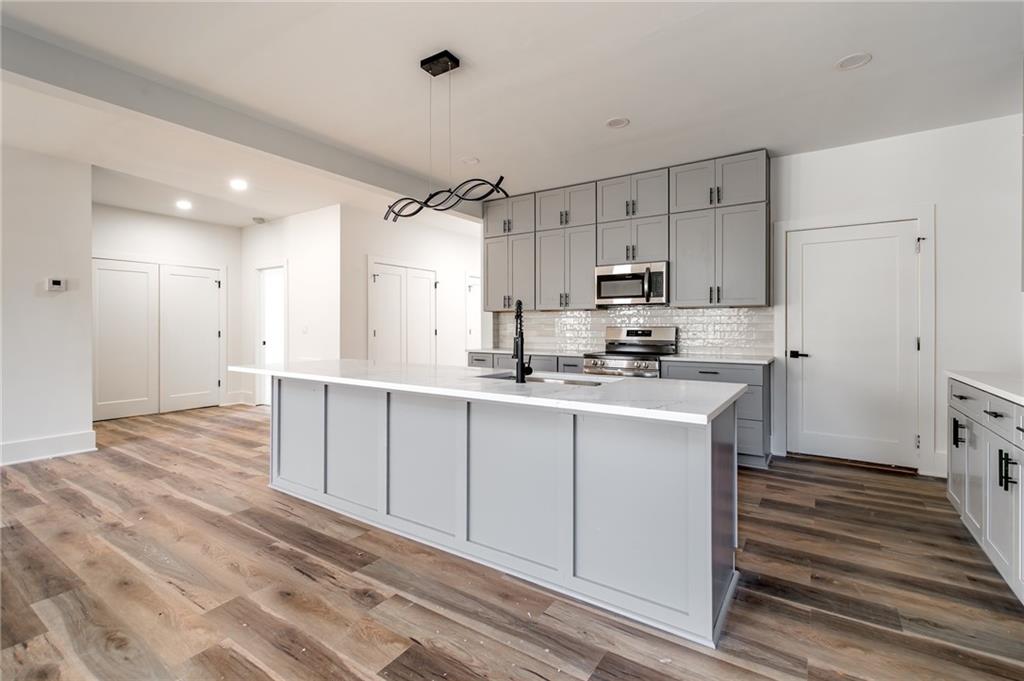 6121 Timberidge Drive Gainesville, GA 30506 - Photo 11 of 44 a kitchen with kitchen island white cabinets stainless steel appliances and a refrigerator