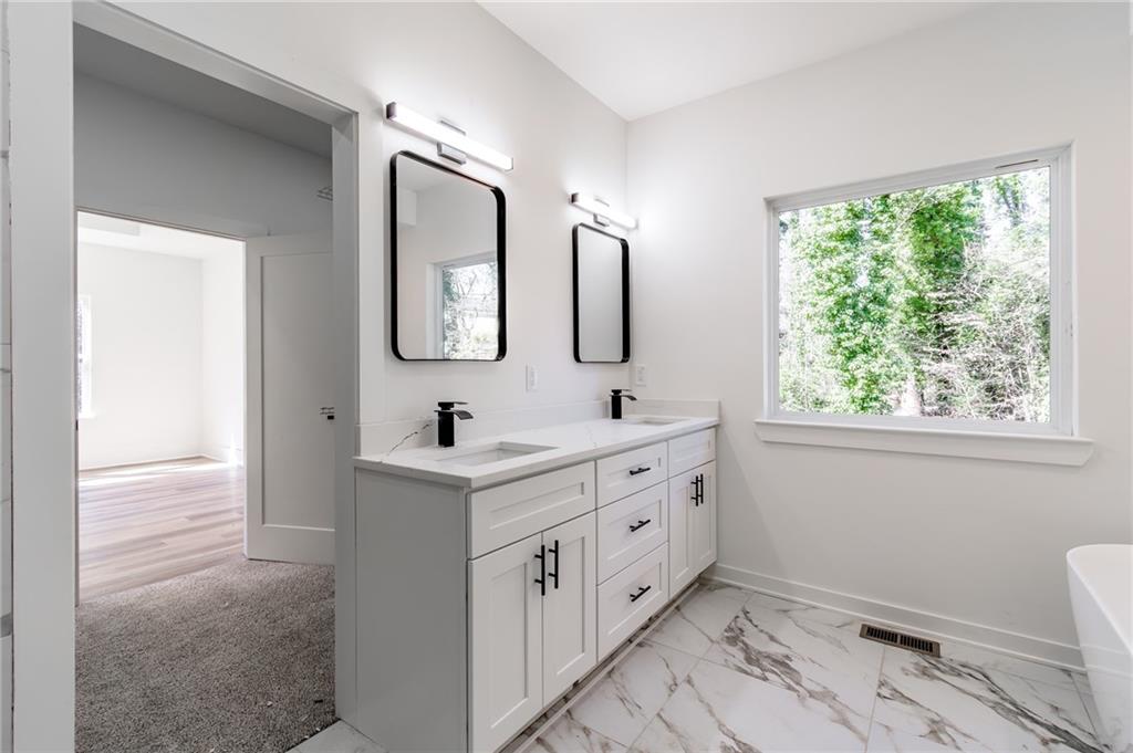 6121 Timberidge Drive Gainesville, GA 30506 - Photo 23 of 44 a spacious bathroom with a double vanity sink mirror and window