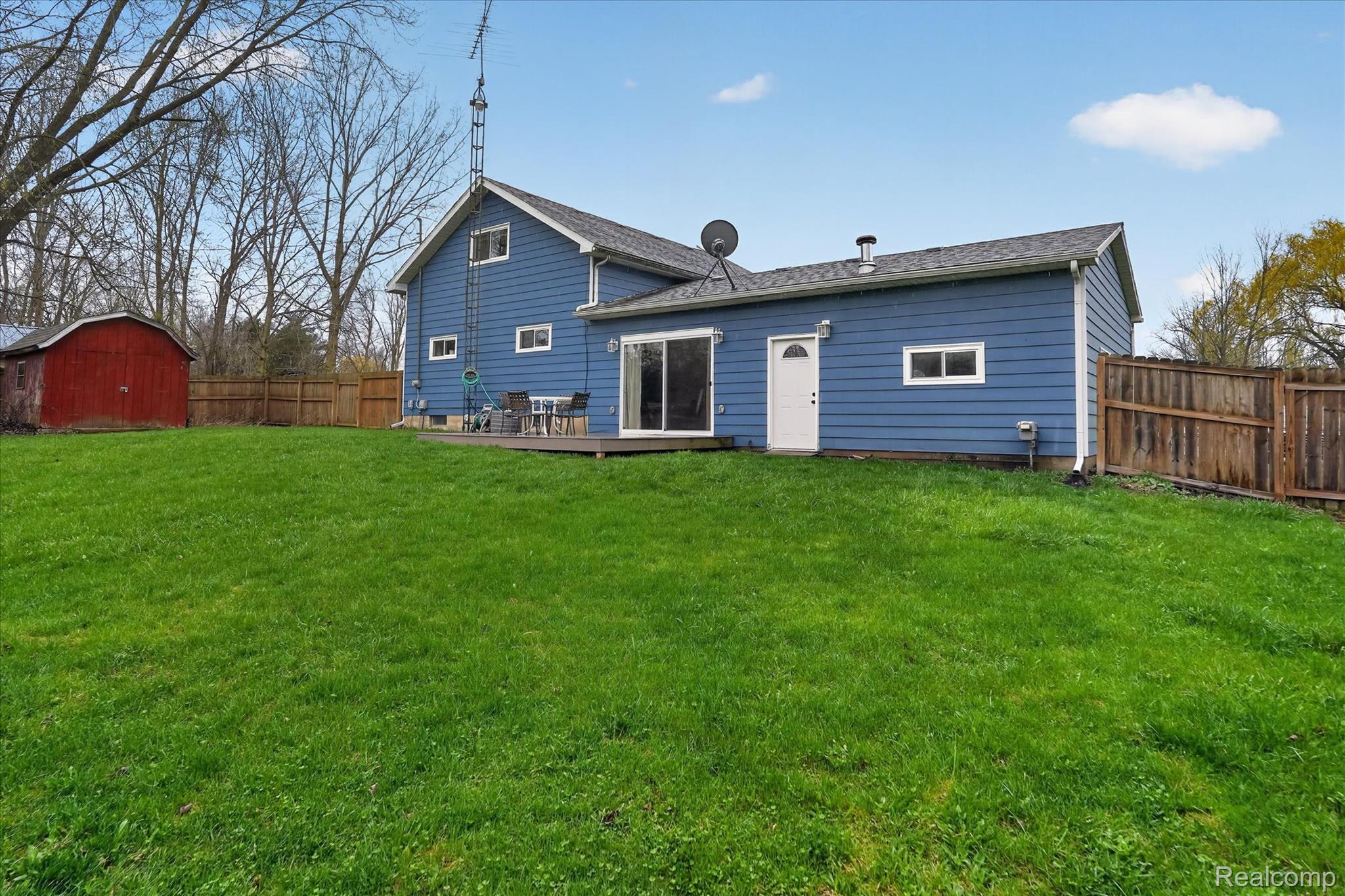 13508 North Center Road Clio, MI 48420 - Photo 35 of 38 Rear view of property featuring a storage shed, a fenced backyard, a wooden deck, and roof with shingles