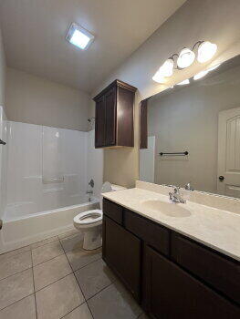 3205 112th Street Lubbock, TX 79423 - Photo 10 of 19 a bathroom with a double vanity sink a toilet and a large mirror