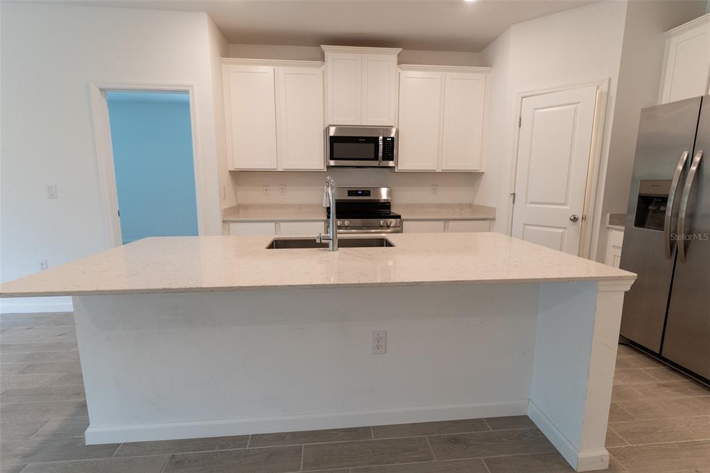4501 Northwest 14th Loop Ocala, FL 34482 - Photo 20 of 38 a kitchen with a microwave a stove and a refrigerator