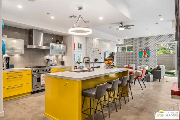 a kitchen with stainless steel appliances kitchen island granite countertop a table and chairs in it