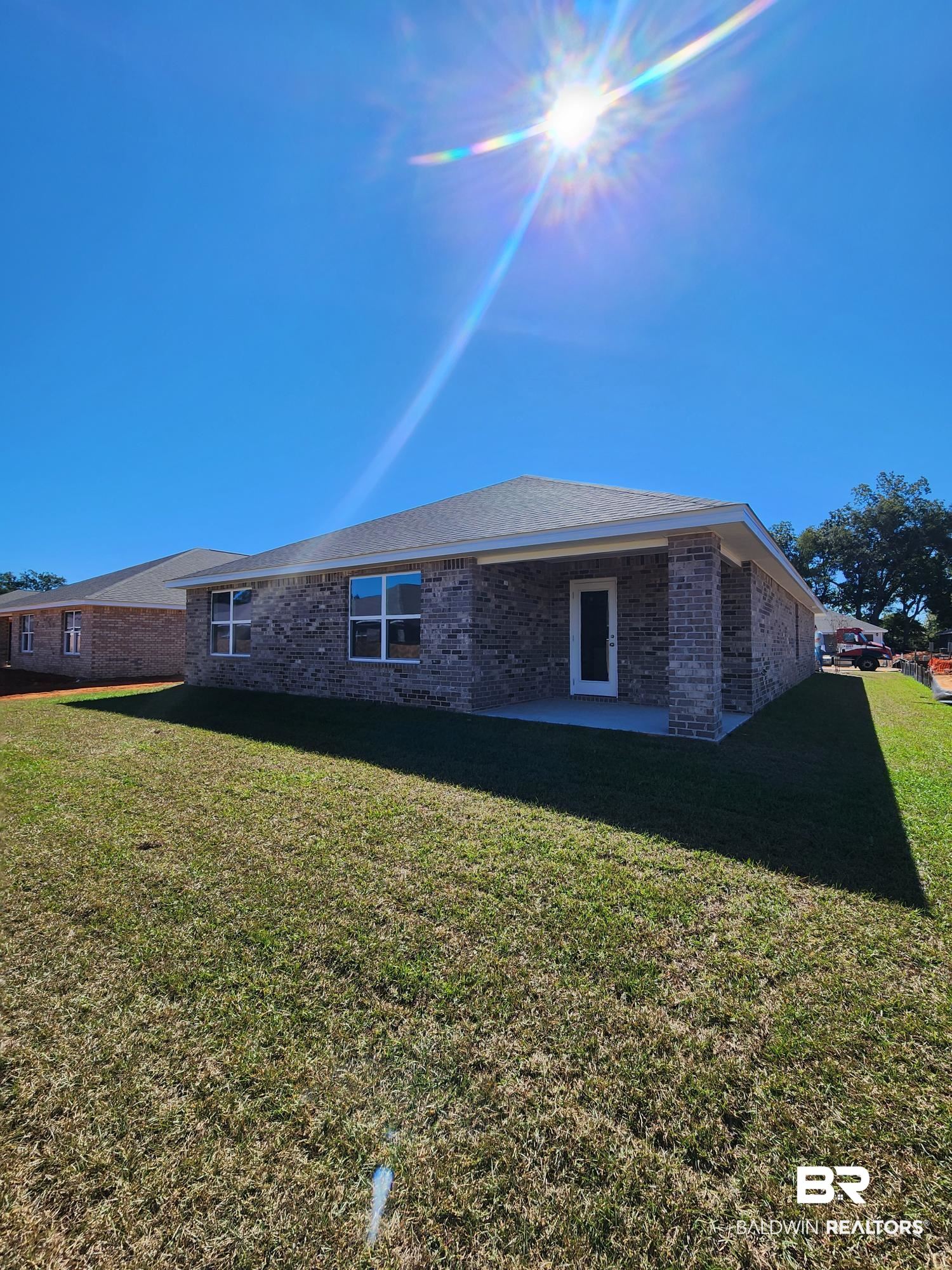 24671 Ponder Loop Loxley, AL 36551 - Photo 2 of 8 View of side of home with a patio area and a lawn