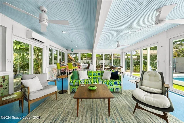 a backyard of a house with table and chairs under an umbrella