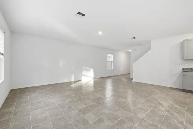 a view of kitchen with kitchen island a sink wooden floor and a refrigerator