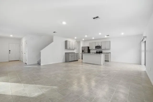 a large kitchen with stainless steel appliances a large counter top and a stove