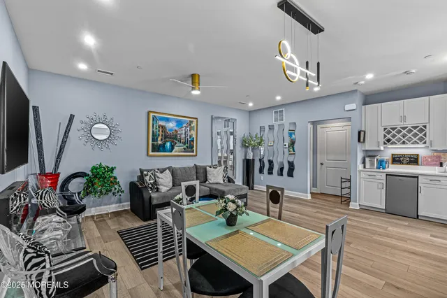 a living room with furniture kitchen view and a potted plant