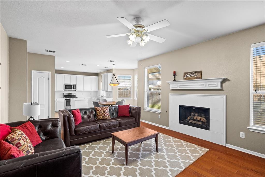 3508 Bratton Ridge Crossing Austin, TX 78728 - Photo 6 of 18 Hardwood floors and an inviting fireplace anchor this warm living area, flowing seamlessly into the kitchen.
