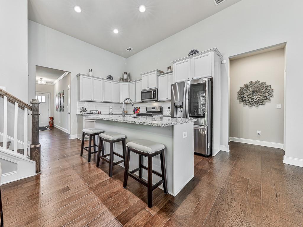 200 Lakeside Place Canton, GA 30114 - Photo 25 of 38 a kitchen with stainless steel appliances a refrigerator a stove top oven and a center island with wooden floor