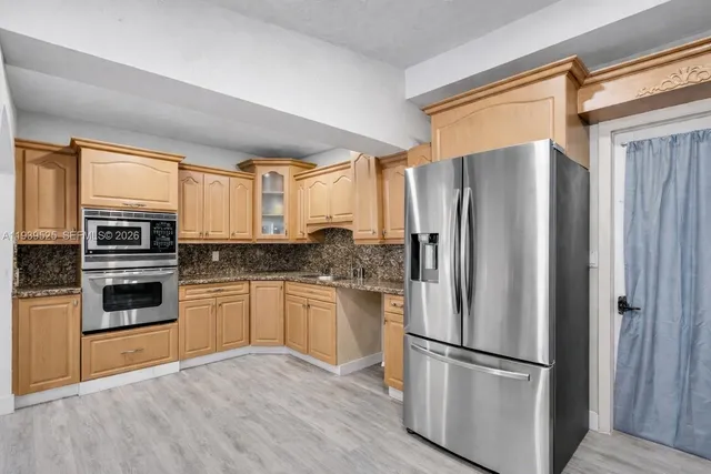 a kitchen with stainless steel appliances granite countertop a refrigerator microwave and stove