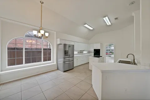 a kitchen with refrigerator and cabinets