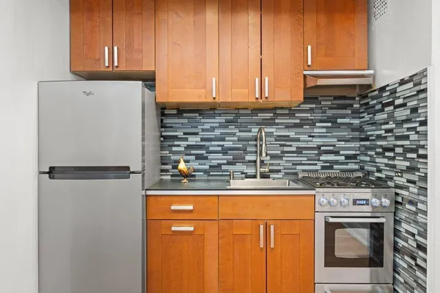 a kitchen with stainless steel appliances a refrigerator and a stove top oven